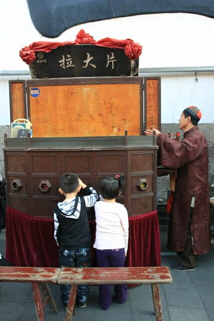 Kids Watching a Puppet Show in Hangzhou Old Street